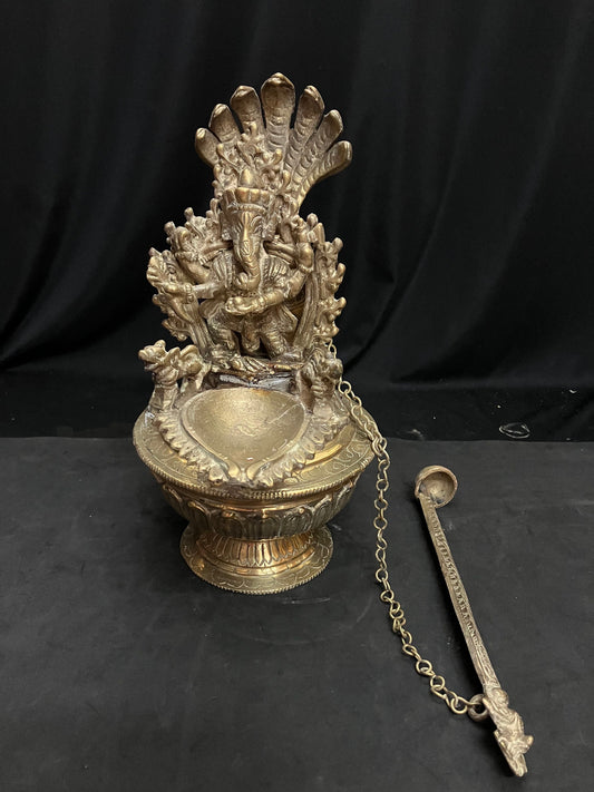 vintage brass cast north india style oil lamp with ganesha and spoon for the oil with lotus base