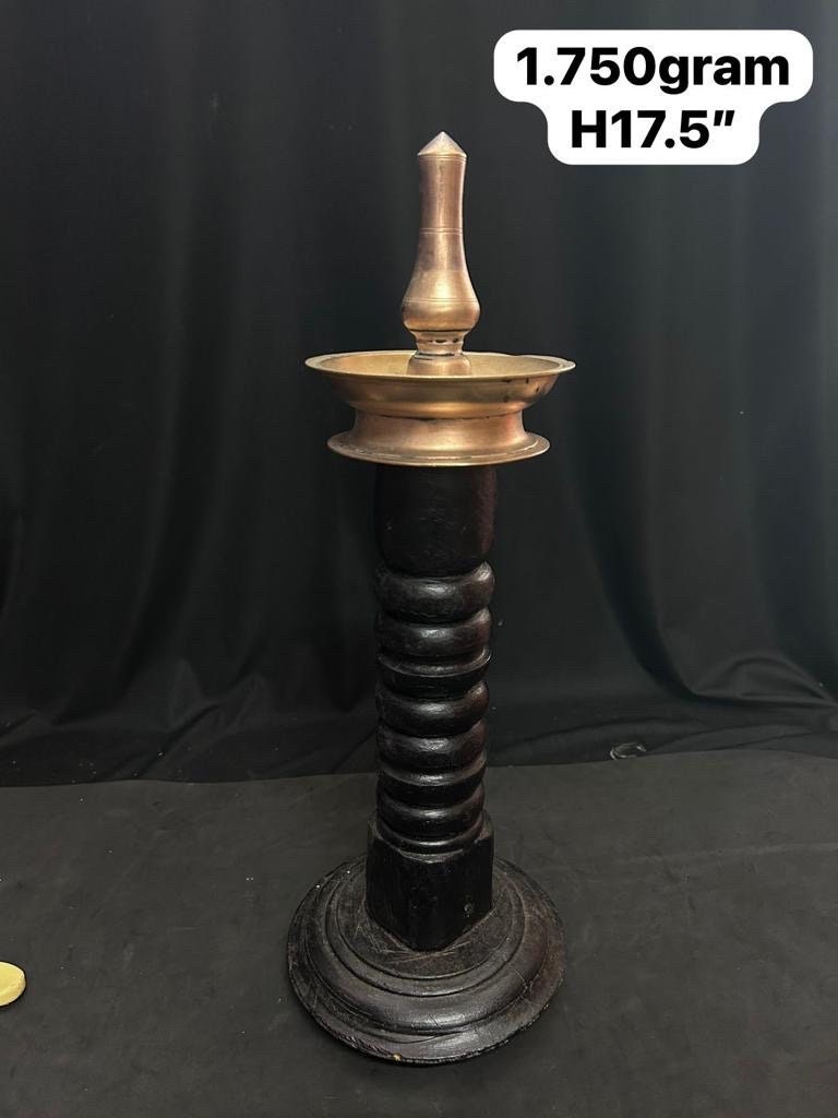 Vintage bronze casted oil lamp mounted on a wooden pillar